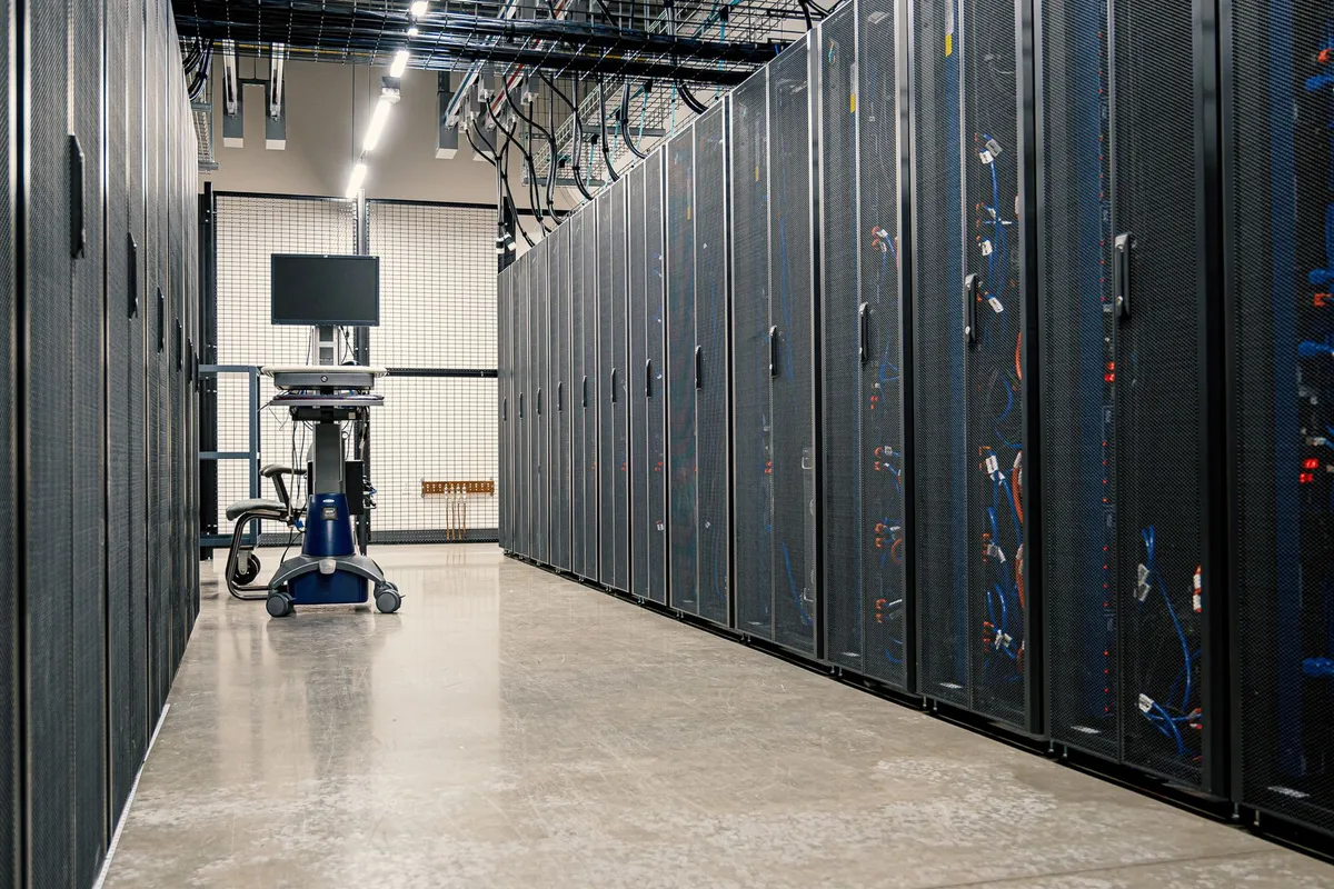 Rows of server racks and network equipment in a data center